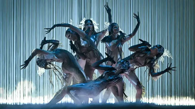 Latvia entry performs in white and black body suits while moving on stage