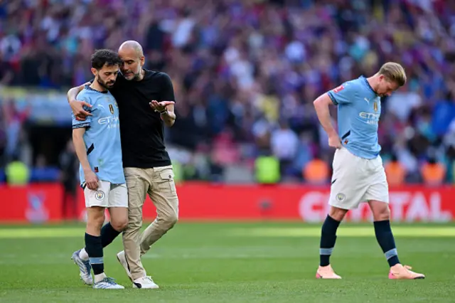 Pep Guardiola, Manager of Manchester City, interacts with Bernardo Silva