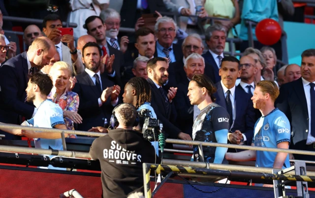 Manchester City's Bernardo Silva, Jeremy Doku, Jack Grealish and Kevin De Bruyne collect their runner up medals from Britain's Prince William