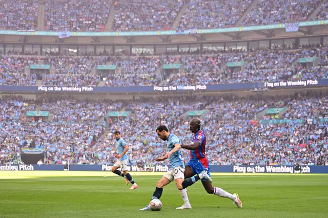 Bernardo Silva of Manchester City is challenged by Jean-Philippe Mateta