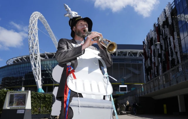 Joe Feely playing a trumpet outside the stadium