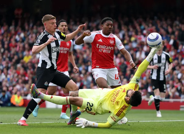 Newcastle United's Harvey Barnes in action with Arsenal's David Raya and Myles Lewis-Skelly