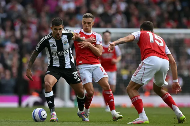 Newcastle United's Brazilian midfielder #39 Bruno Guimaraes (L) vies with Arsenal's Belgian midfielder #19 Leandro Trossard (C) and Arsenal's Polish defender #15 Jakub Kiwior (R) during the English Premier League football match between Arsenal and Newcastle United