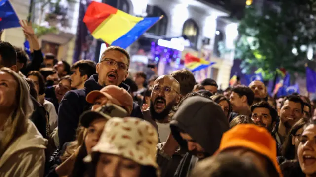 Supporters of presidential candidate Nicusor Dan react to first exit polls of Romania's second round of the presidential election, in Bucharest, Romania, May 18, 2025