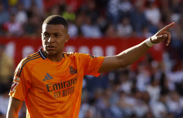 Kylian Mbappe holds out his arm
