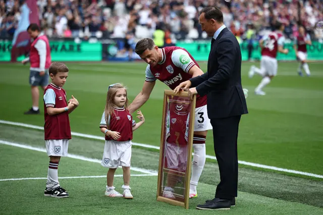 West Ham United's English defender #03 Aaron Cresswell is presented with a framed shirt ahead of the English Premier League football match between West Ham United and Nottingham Forest at the London Stadium, in London on May 18, 2025.