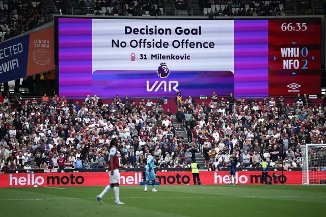 A screen shows the decision of the long VAR chack on a goal by Nottingham Forest's Serbian defender #31 Nikola Milenkovic