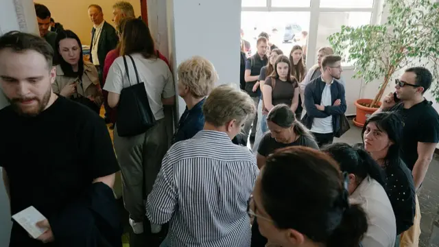 Men and women queue up inside a polling station to cast their votes in the presidential election in Bucharest, Romania