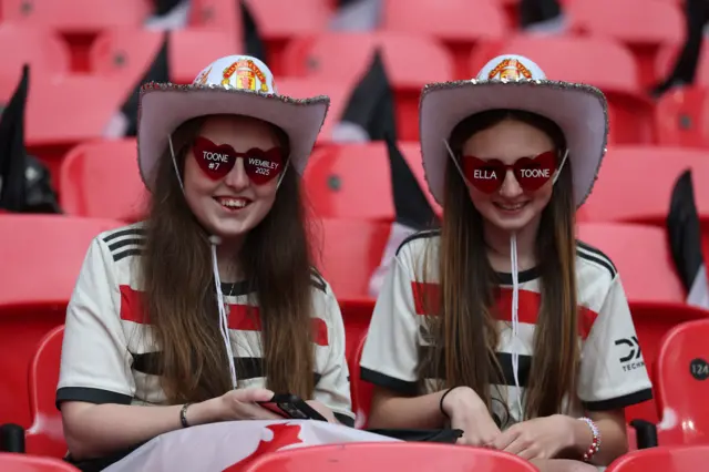 Two Manchester United fans pose for a photo inside Wembley