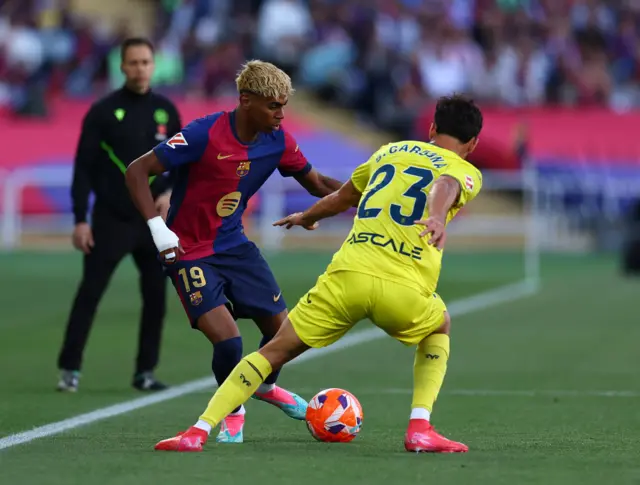 Lamine Yamal flicks the ball away from Sergi Cardona