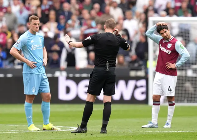 Referee Sam Barrott conducts a VAR check (centre) for the goal of Nottingham Forest's Nikola Milenkovic