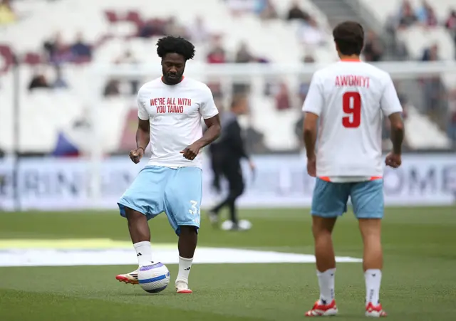 Ola Aina of Nottingham Forest warms up whilst wearing a t-shirt in support of team mate Taiwo Awoniyi prior to the Premier League match between West Ham United FC and Nottingham Forest FC at London Stadium