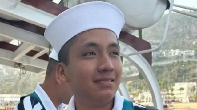 Adal Jair Maldonado wearing a Navy uniform and a white cap