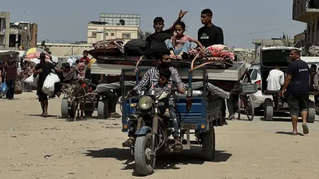Palestinians leave Khan Younis with belongings on a bike