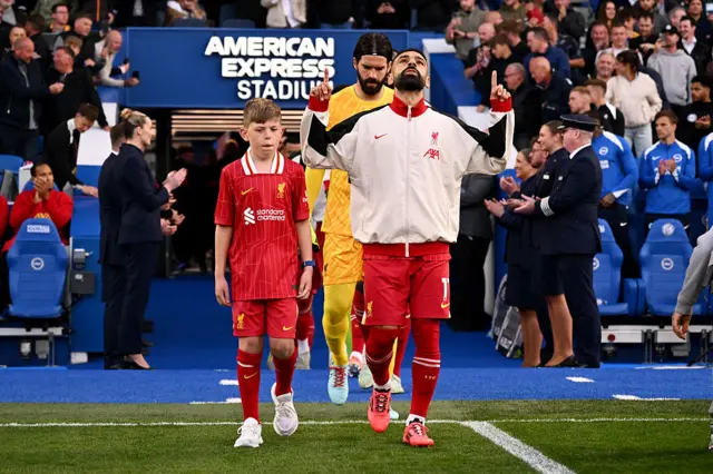 Mohamed Salah of Liverpool gestures, as he leads the team out prior to the Premier League match between Brighton & Hove Albion FC and Liverpool FC at Amex Stadium on May 19, 2025 in Brighton, England.