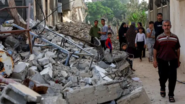 Palestinians inspect the site of an Israeli strike in Khan Younis on Monday morning