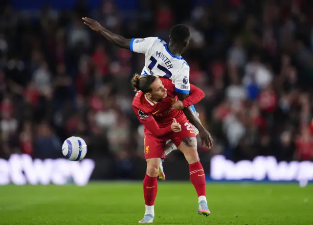 Liverpool's Kostas Tsimikas and Brighton and Hove Albion's Yankuba Minteh battle for the ball