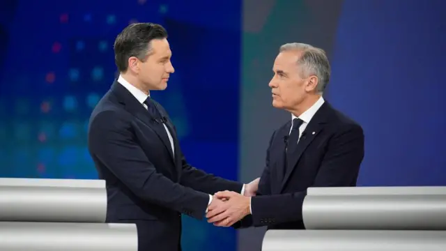 Conservative Leader Pierre Poilievre and Liberal Leader Mark Carney shake hands following the English-language federal leaders' debate in Montreal, Canada, April 17, 2025. They are both wearing black suit over white shirts.