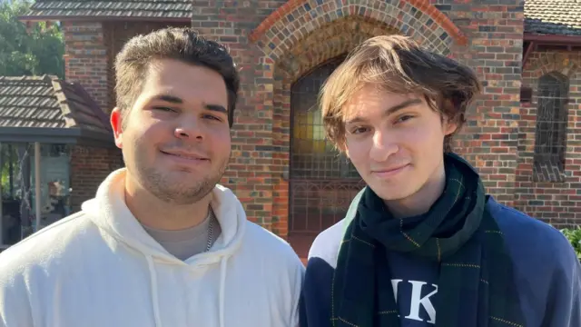 Two students in Melbourne are pictured outside an early polling station.