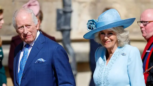Charles and Camilla smiling as they walk together outside