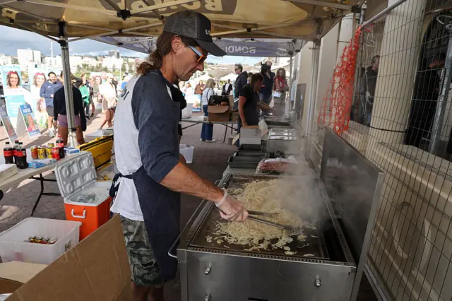 A man grills sausages for voters who have cast their ballots in Australia's general election outside a polling station at the Bondi Surf Bathers Life Saving Club