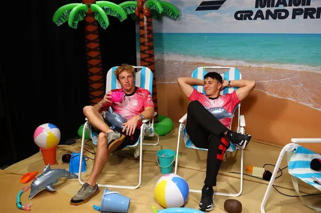 Liam Lawson and Isack Hadjar sit in deck chairs
