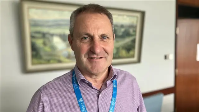 Ian Nellins has short brown and grey hair and is wearing a red and blue shirt, with a blue Shropshire Council lanyard