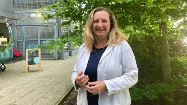 Lucy Nethsingha standing in front of a tree