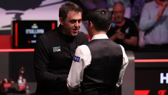 Ronnie O'Sullivan shakes hands with Zhao Xintong