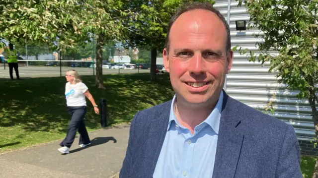 A picture of the Mid Bucks Conservative MP Greg Smith - he is wearing a blue jacket and a light blue shirt.