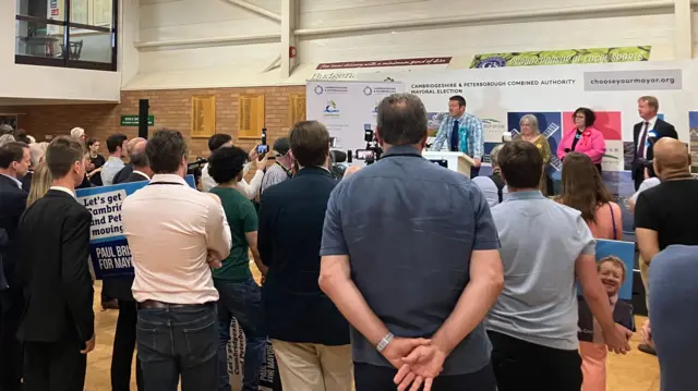 Ryan speaking on the podium with people standing in front watching
