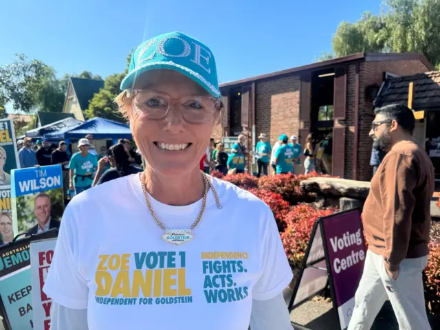Independent Teal candidate, Zoe Daniels, in pictures on the campaign trail.  She is wearing a teal colour cap with her name and a white t-shirt promoting her campaign.