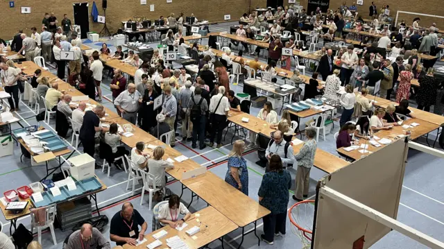 The Olypiad sports hall in Chippenham full of tables and people counting the ballot