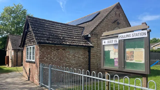 A village hall has a sign saying "Way in, polling station"
