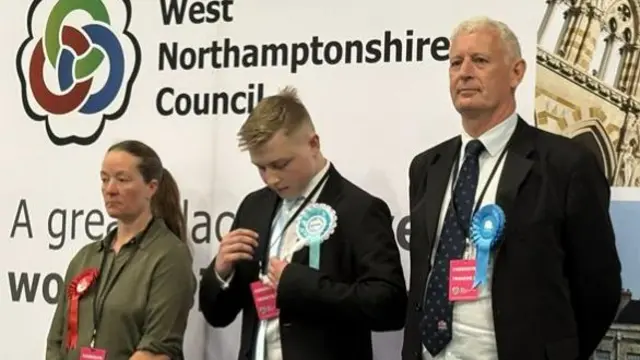 A Labour, Reform UK and Conservative candidate all dressed smartly on stage as the results are announced.