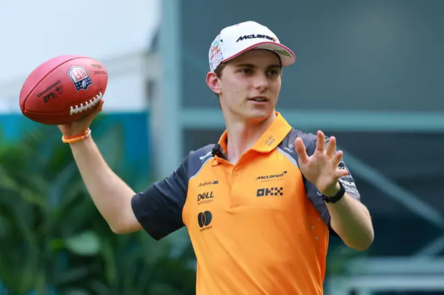 Oscar Piastri throws an American football