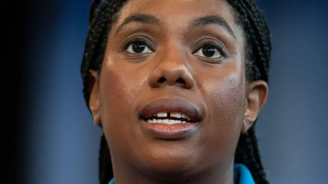 A woman with black hair looking upwards