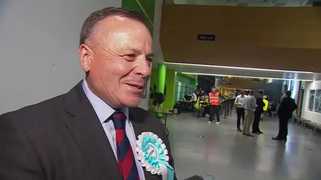 Arron Banks, wearing a Reform rosette, speaks