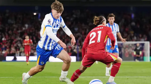 Harry Howell takes the ball past Kostas Tsimikas as he makes his Premier League debut for Brighton against Liverpool
