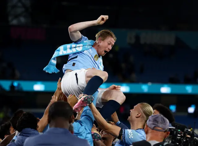 Manchester City's Kevin De Bruyne is thrown in the air by teammates