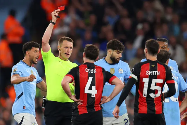 Referee Thomas Bramall shows a red card to Lewis Cook of Bournemouth after a challenge on Nico Gonzalez