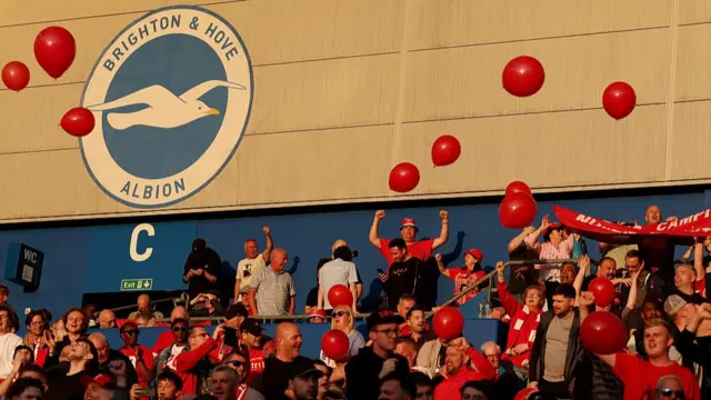 Liverpool fans surrounded by red balloons