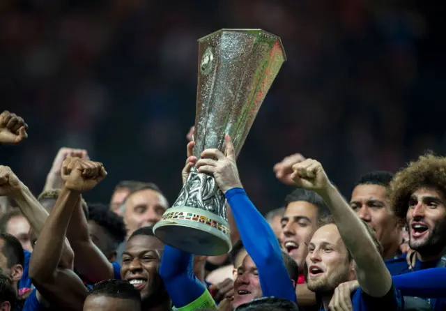 The trophy is held aloft by Wayne Rooney after winning the the Europa League