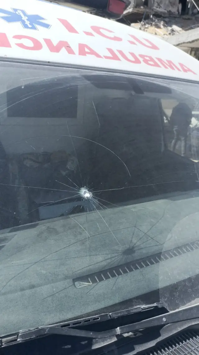 Photo of ambulance with bullet hole in windscreen