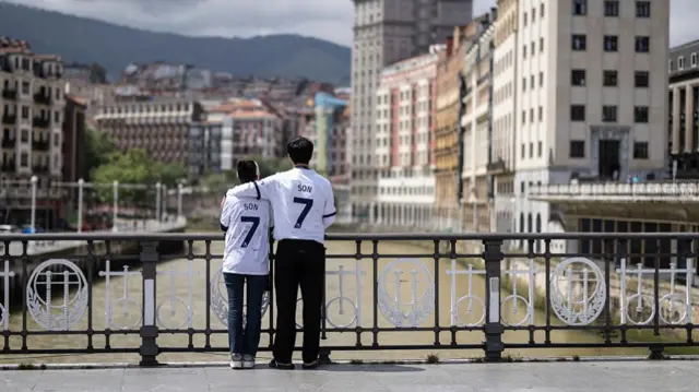 Fans of Son Heung-Min pose on a bridge