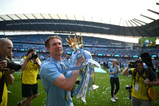 Manchester City's Belgian midfielder #17 Kevin De Bruyne poses with the Premier League trophy after the presentation ceremony in 2024.