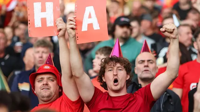 Two Liverpool fans with party hats on