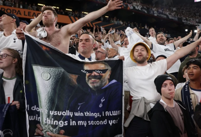 Tottenham Hotspur fans celebrate with a banner of manager Ange Postecoglou after winning the Europa League