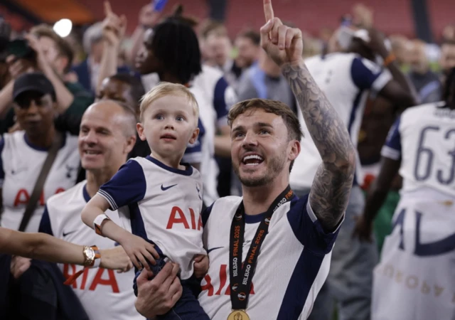 Tottenham Hotspur's James Maddison celebrates with his son