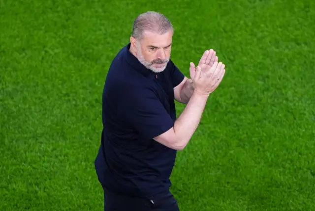 Ange Postecoglou claps the fans as he walks onto the pitch